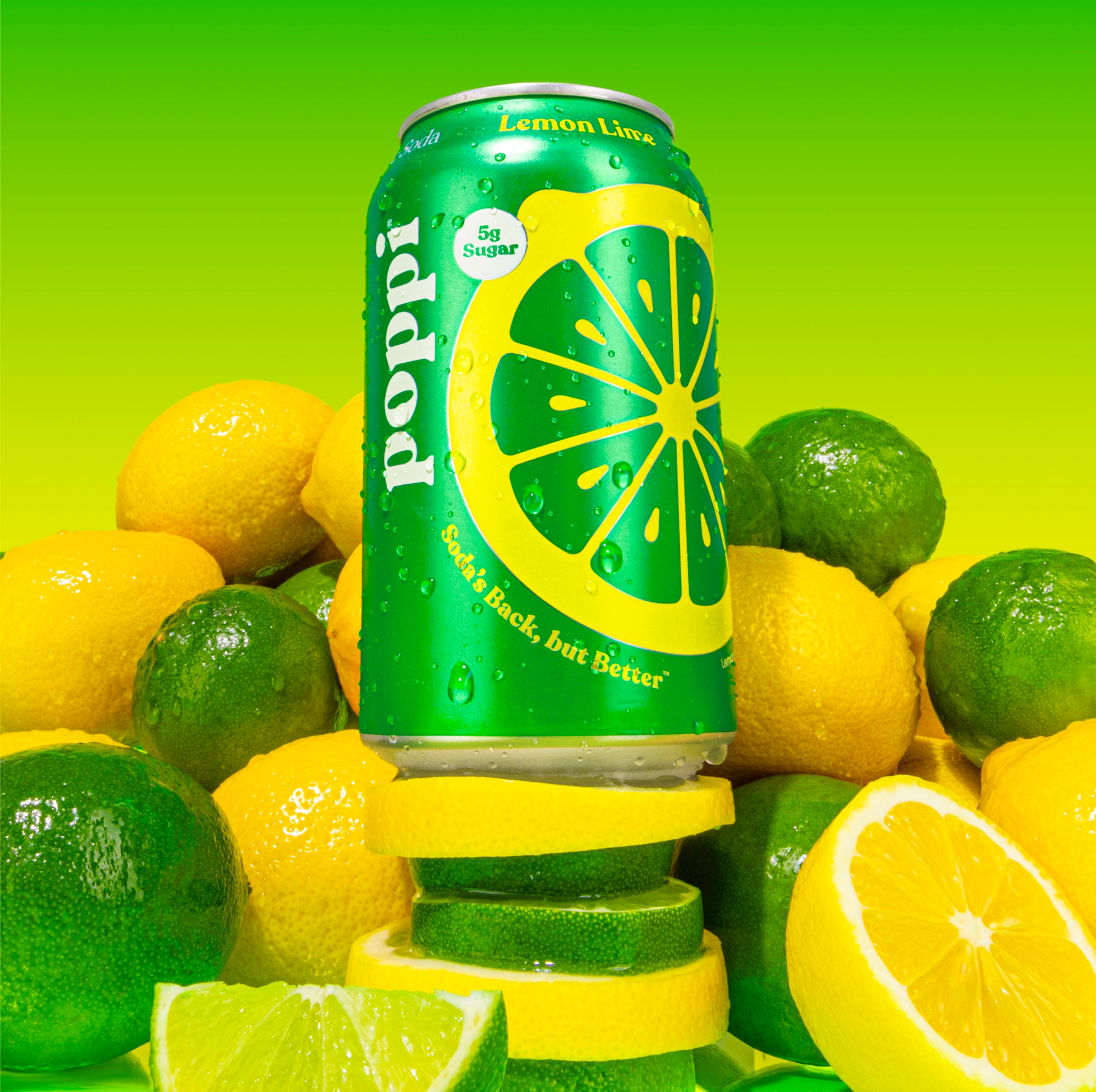 Зелёно-жёлтая банка газировки Poppi Lemon Lime среди лимонов и лаймов