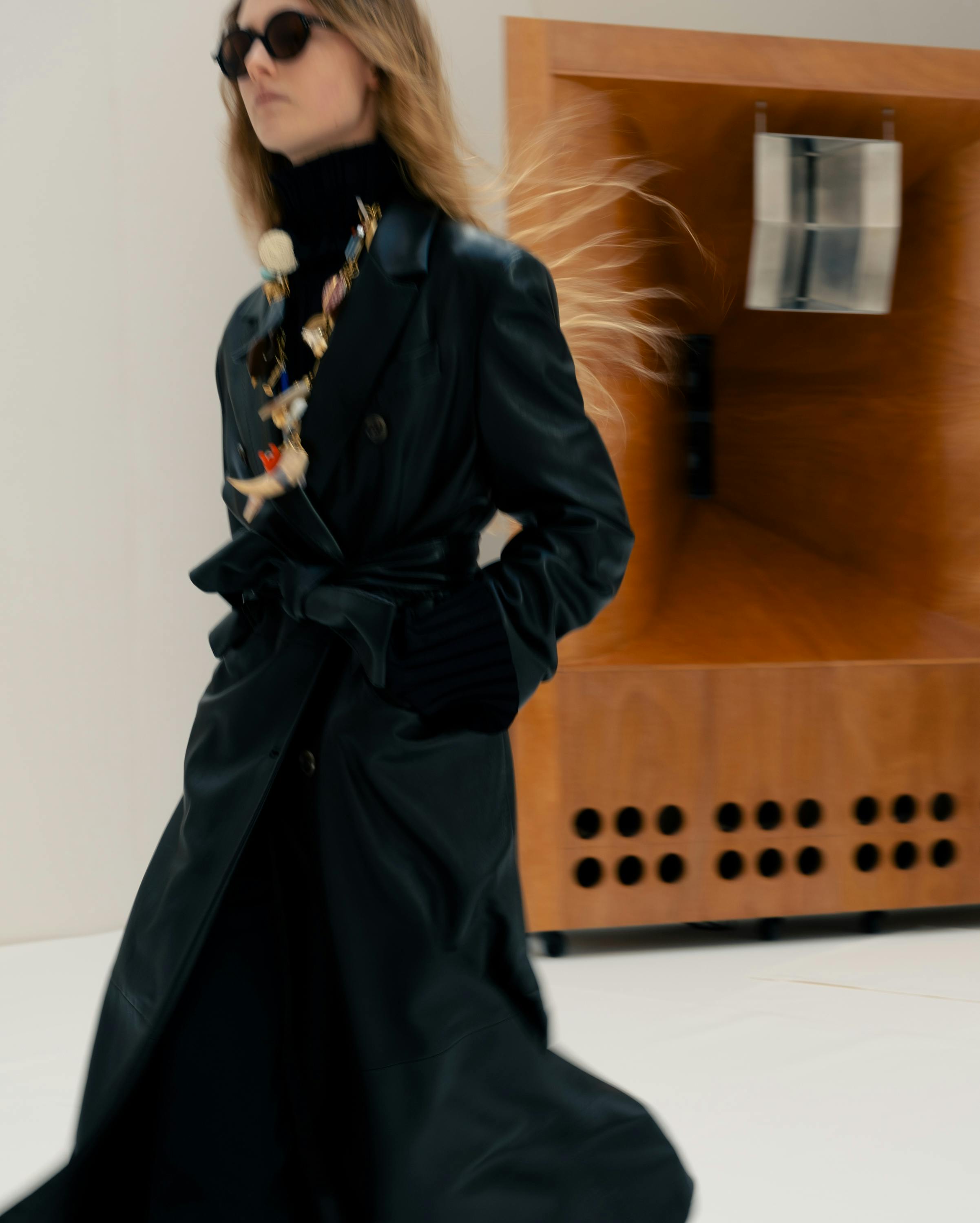 Модель на показе Celine проходит рядом с большой деревянной колонкой с металлическим рупором